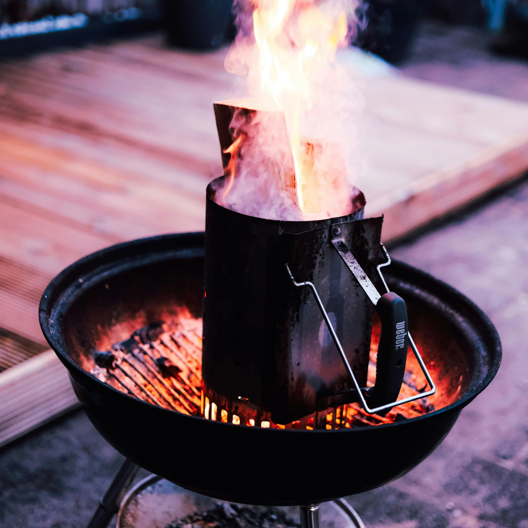 Brandende brikkettenstarter met vlammen op een houtskoolbarbecue
